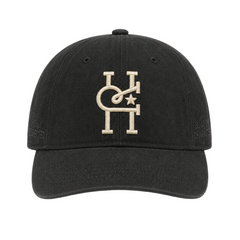 A black baseball cap featuring a beige embroidered monogram logo on the front, photographed against a solid white background.